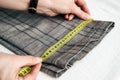 Tailor using a measure tape to measure width of pants