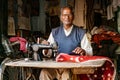 Tailor woks on manual sewing machine, creating tablecloth