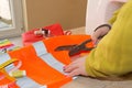 Tailor Woman, fashion designer working at studio. Fashion designer cutting textile next to a sewing machine