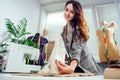 Tailor woman measuring shirt sleeve using tape meter, working in dressmaking studio showing perfect jacket layout Royalty Free Stock Photo