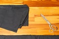 Tailoring Concepts. Old Metal Rusty Scissors Placed Together with Black Fabrics on wooden Surface Royalty Free Stock Photo