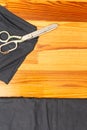 Tailoring Concepts. Old Metal Rusty Scissors Placed Together with Black Fabrics on wooden Surface Royalty Free Stock Photo