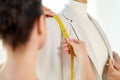 Fashion designer measures jacket with tape measure Royalty Free Stock Photo