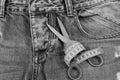 Tailors tools on denim fabric: scissors and yellow measure tape Royalty Free Stock Photo