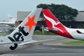 Tails of Jetstar International and Qantas aircraft belonging to the same family at Changi Airport