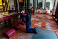 Tainan, Taiwan, Asia, October 12, 2019 People of Asian appearance kneel to pray and burn incense sticks in front of an altar with Royalty Free Stock Photo