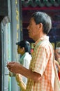 Taipei Taiwan - May 13th 2017: Old Asian man with prayer sticks praying in Longshan Temple. Religious ceremony, religion rituals.