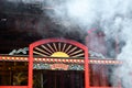 Taipei, Taiwan - May 13th 2017: Smoke cloud from incense sticks over red entrance in amazing Lungshan Temple in Taipei, Taiwan.