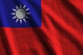 Taiwan flag with big folds waving close up under the studio light indoors. The official symbols and colors in banner