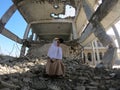 A Yemeni girl sits inside her destroyed school