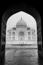 Taj Mahal in black and white framed by the arc of the mosque in Agra