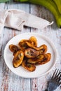 Tajadas fried banana on a plate on the table vertical view Royalty Free Stock Photo