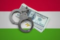 Tajikistan flag with handcuffs and a bundle of dollars. Currency corruption in the country. Financial crimes