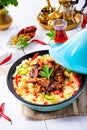 Tajin with couscous, vegetables and meat on white background