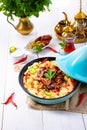 Tajin with couscous, vegetables and meat on white background