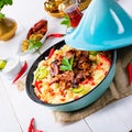 Tajin with couscous, vegetables and meat on white background