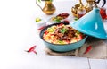 A Tajin with couscous, vegetables and meat on white background