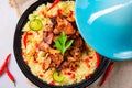 A Tajin with couscous, vegetables and meat on white background