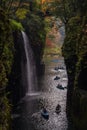 View into the Takachiho gorge, with people in little boats trying to get close to the waterfall