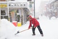 Takayama, Japan - January 16,2017 : Old japanese man with snow shovel removing snow on the road in winter time at Takayama Royalty Free Stock Photo