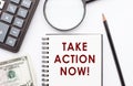 Take action now. Motivation text written on notebook with calculator, magnifier, dollar bills and pen Royalty Free Stock Photo