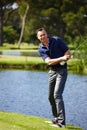 Take aim and let fly. a man taking a swing in a game of golf. Royalty Free Stock Photo