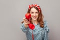 Take it, answer call! Charming happy pinup girl giving phone handset looking at camera, smiling looking friendly joyful Royalty Free Stock Photo