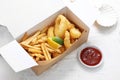 Deep fried calamari, squid rings in tempura and fries, in a take-away carton box, on a white background. Royalty Free Stock Photo