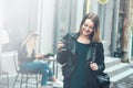 Take away coffee. Beautiful young urban woman wearing in black stylish clothes holding coffee cup and smiling while walking along Royalty Free Stock Photo