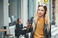 Take away coffee. Beautiful young urban woman wearing in stylish clothes holding coffee cup and smiling while walking Royalty Free Stock Photo