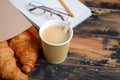 Take away coffee cup with croissant on wooden table. Royalty Free Stock Photo