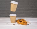 Take Away Coffee in Paper Eco Cup and Fresh Croissant With Chocolate drops on wooden background, Copy Space, Flying food, Royalty Free Stock Photo