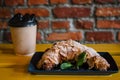 Take away coffee and fresh croissant with mint on wooden background. Cardboard cup with face cap concept Royalty Free Stock Photo