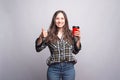 Take away coffee. Happy young woman showing thumb up and holding Royalty Free Stock Photo