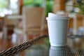 Take away cup for hot coffee drink put on glass table inside garden cafe Royalty Free Stock Photo