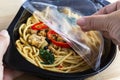 Take-away food ready meal: Woman hands holding open cling wrap a