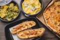 Take away italian pasta food. Pizza with box green peppers, garlic bread, fetuccine and ravioli on plastic box Royalty Free Stock Photo