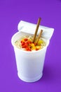 Take away noodles with vegetables on violet background Royalty Free Stock Photo