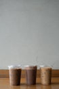 Take away plastic cup of iced chocolate, iced mocha and iced latte on table