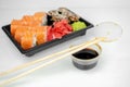 Take away sushi in plastic containers, philadelphia rolls and unagi maki, soy sauce, pink ginger, wasabi, sushi delivery concept Royalty Free Stock Photo