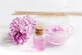 Take bath with lilac cosmetic set and blossom on white table background Royalty Free Stock Photo