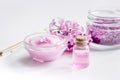 Take bath with lilac cosmetic set and blossom on white table background Royalty Free Stock Photo