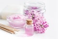 Take bath with lilac cosmetic set and blossom on white table background Royalty Free Stock Photo