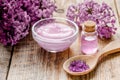 Take bath with lilac cosmetic set and blossom on wooden table background