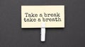 Take a break,take a breath text on paper with wihte clip. On black background