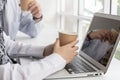 Take a break. business people hand holding hot coffee cup working and communicating on laptop computer at modern office Royalty Free Stock Photo