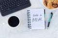 Take a break. Concept time off. Words Take a break in a notebook on the working table with cup of coffee and bun Royalty Free Stock Photo