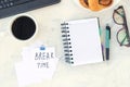 Take a break. Concept time off. Words Take a break in stiker on the working table with cup of coffee and bun Royalty Free Stock Photo