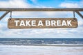 Take a break wooden sign against beach Royalty Free Stock Photo