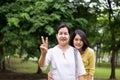 Take care and support concept,Portrait of middle aged asian woman with daughter showing 2 fingers at park together,Happy and smili Royalty Free Stock Photo